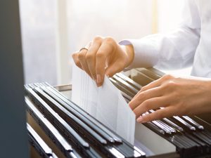 Office clerks hand filing document